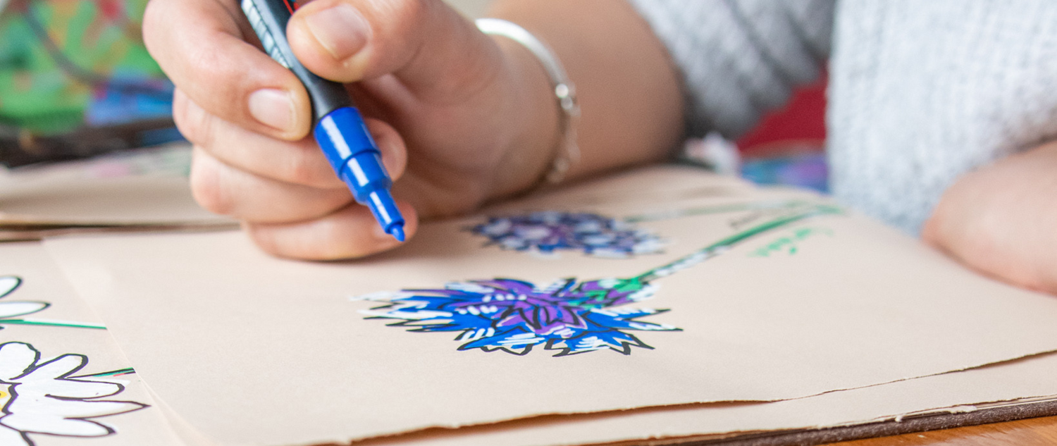 blue and purple illustration of a flower in progress lady holding blue paint marker  